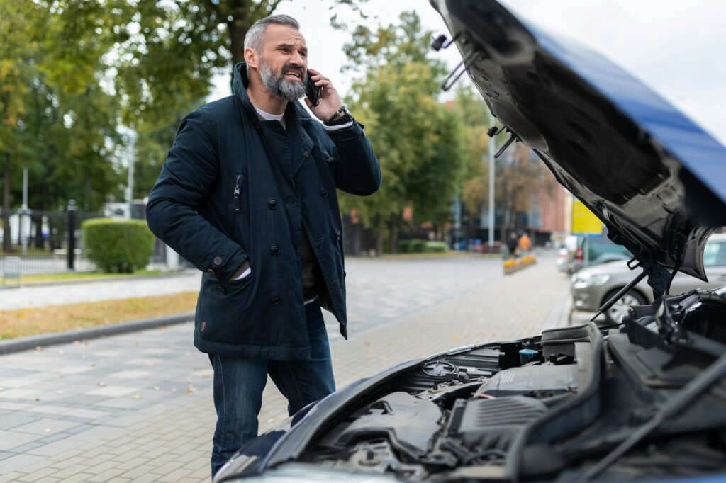 a man calls a tow truck next to a broken car in the city